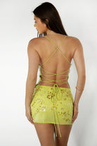 Model wearing the TIC TOC SL31480 VEDA brown chiffon beaded low-rise mini skort featuring hand-beaded floral embroidery, chiffon overlay, and built-in shorts with matching cami top in an outdoor setting. 