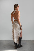 Woman wearing TIC TOC TSC31024 ALMEDA multi animal print mesh print halter top and matching maxi skirt set featuring a deep V halter, scarf hem, and high-slit mesh skirt