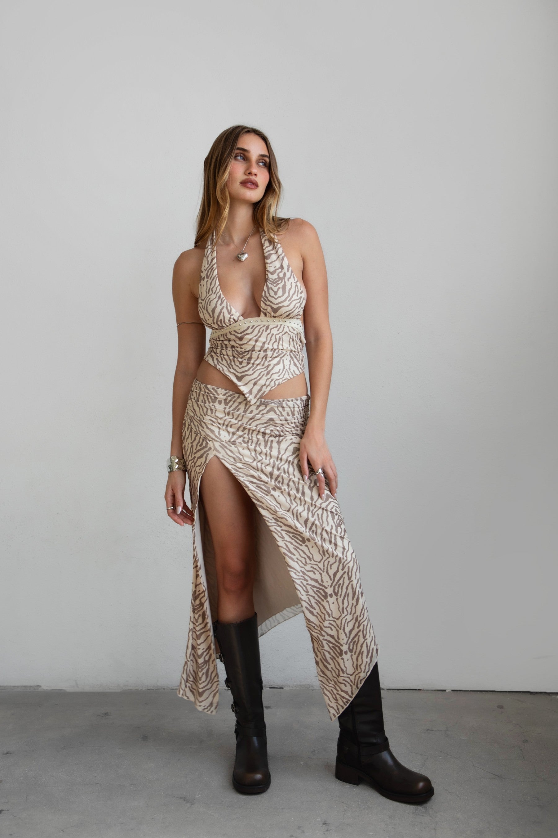Woman wearing TIC TOC TSC31024 ALMEDA multi animal print mesh print halter top and matching maxi skirt set featuring a deep V halter, scarf hem, and high-slit mesh skirt